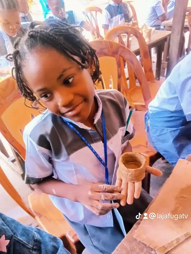 Une élève montre le gobelet qu'elle vient de modeler