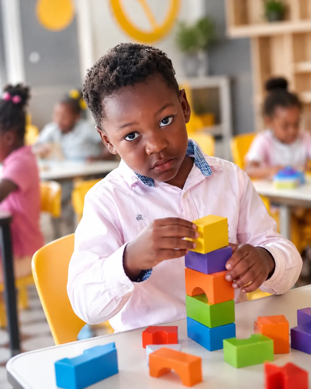 Un enfant de maternelle empile des cubes